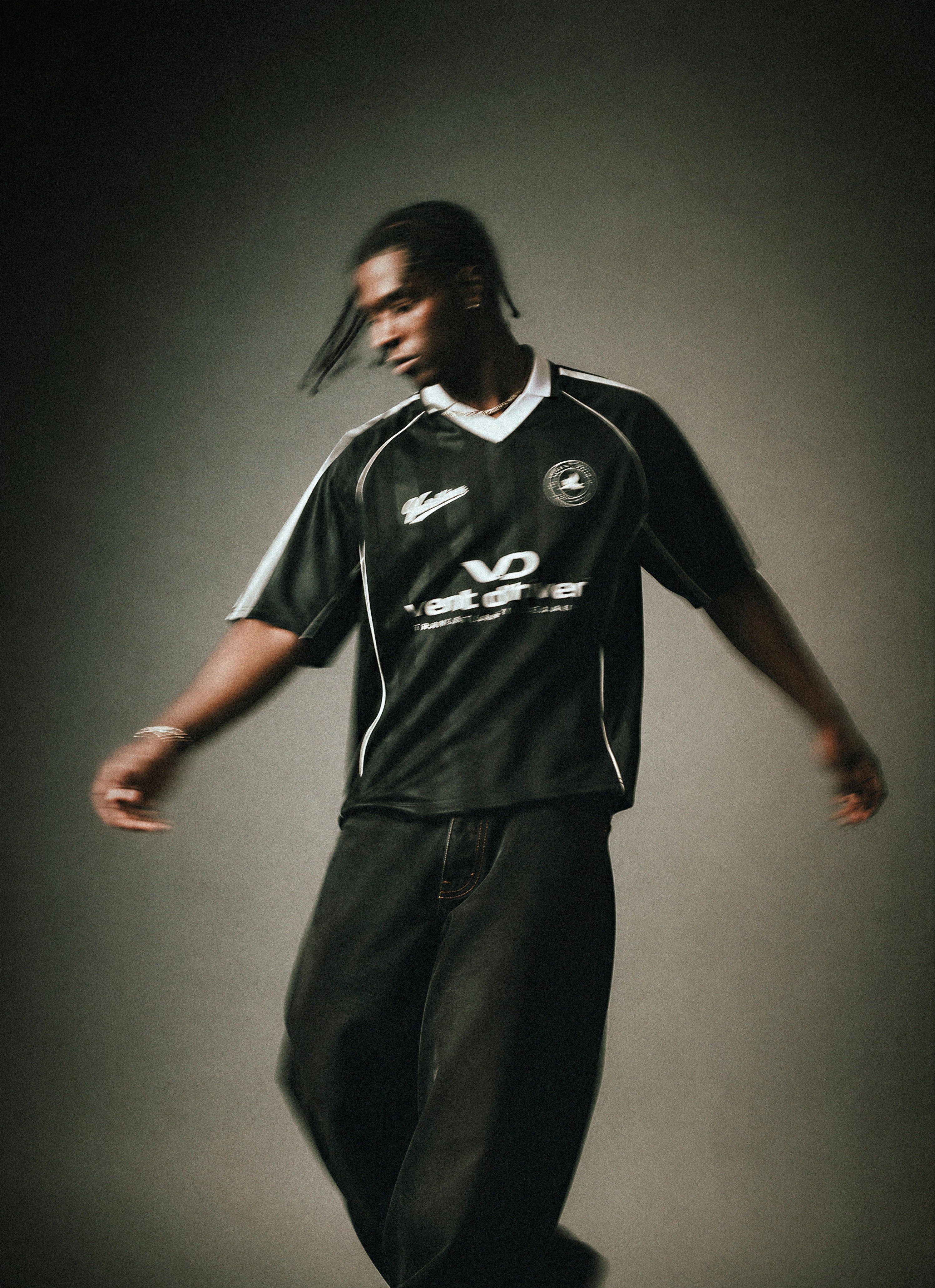 Person wearing a black sports outfit with visible branding on a dark background
